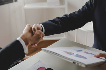 Wall Mural - group business investor people partner handshake after finishing up business meeting with financial statistics report on desk in office, negotiation, investment, partnership and financial concept