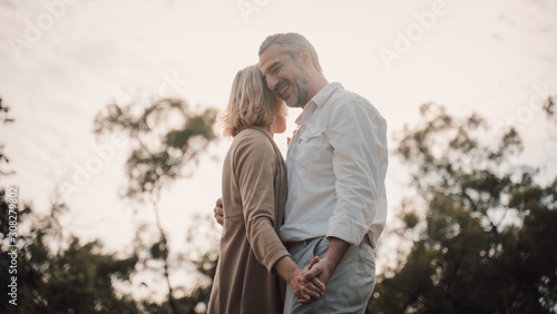 Older Lover and dating concept.Beautiful Senior couple romantic dancing in park.mature couple in summer park.Elderly man and old woman in love dancing outdoors.