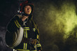 © alfa27 - brave extinguisher or fireman dressed in dark protective suit uniform, with helmet on head, using ropes, hammer and other special equipment at work