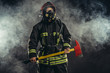© alfa27 - young caucasian fireman holding hammer, risking his life to save people from fire, wearing protective uniform