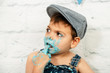 sesión smashcake, primer pastel de un niño de 3 años con pluri discapacidad. disfrutando muchismo mientras come y se ensucia de nata azul
