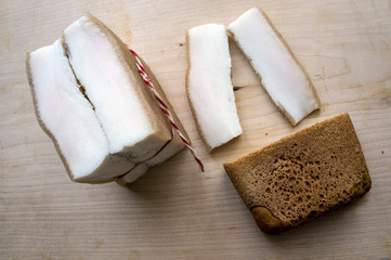 Big slice of bacon and near two cube with rye bread 