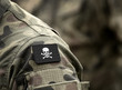© Bumble Dee - Jolly Roger pirate flag on military uniform. A skull and crossbones or death's head a symbol of death.