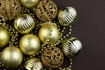 Wall Mural - Golden sparkly Christmas balls on brown background. Magic holiday card. Christmas or New Year festive composition.