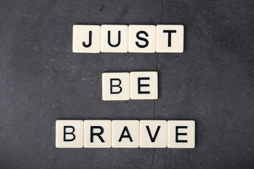 a motivational quote just be brave formed with tile letters