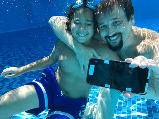 Father and son taking selfie underwater