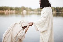 Shallow Focus Shot Of A Female Grabbing The Hand Of Jesus Christ For Healing And Help