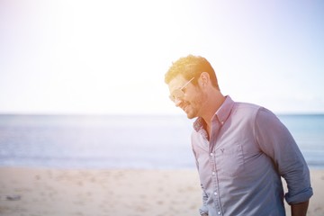 Poster - Shallow focus shot of a male wearing sunglasses and smiling while looking down