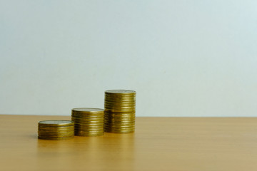 Stack of golden money coin on a wooden table