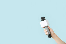 Journalist's Hand With Microphone On Color Background