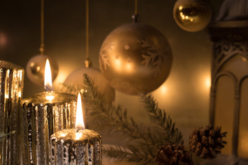 Creative artwork decoration. Christmas decoration with burning candles on a dark background. Christmas ornaments over dark golden background with lights.