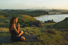 Woman Doing Yoga Alone At Sunrise With Mountain And Ocean View. Harmony With Nature. Self-analysis And Soul-searching