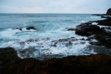 Fototapeta Morze - Waves on the seaside are splashing on the rocks in a stormy day