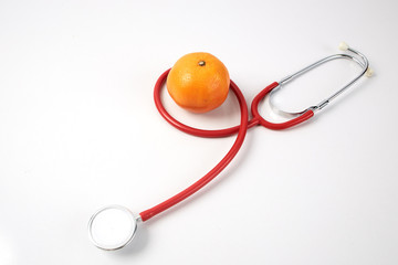 Orange Fruit with Red Stethoscope on white