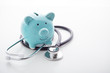 © thanksforbuying - Piggy bank with stethoscope on white background