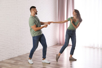 Wall Mural - Lovely young couple dancing together at home