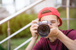 © Valua Vitaly - Teenage boy taking photos outdoors. Young man works reporter, outdoors. Caucasian guy holds a photo camera and capturing photos. 15 years old teenager is with digital photo camera