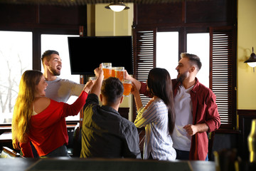 Wall Mural - Group of friends celebrating victory of favorite football team in sport bar