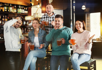 Wall Mural - Group of friends watching football in sport bar