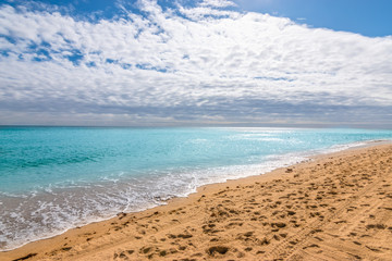 Wall Mural - Hollywood beach with calm turquoise colored ocean, cloudy sky and reflection of the sun into the sea, Fort Lauderdale, Florida.