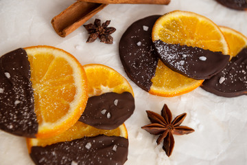 Candied orange in chocolate is a favorite Christmas treat for children and adults. Image of homemade candied orange dipped in chocolate. Top view