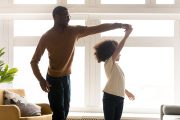 Wall Mural - Loving black dad and daughter dance together at home