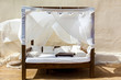 A comfortable canopy bed on the sandy beach