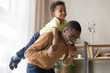 © fizkes - Smiling preschooler boy piggyback playing with dad