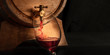 © laplateresca - A panorama of pouring wine into a glass from a barrel, a close-up on a dark background with copy space