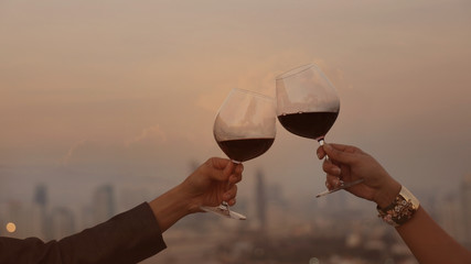 Wall Mural - Happy couple of hand a romantic mood or friendship which happy moment relaxing ,red,wineglass,celebration on the rooftop with sunset sky scene