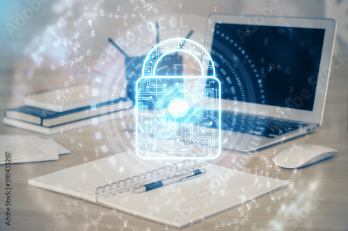 Fotografía Double exposure of desktop with computer and lock icon hologram