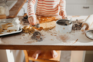 4 years cute girl making traditional Christmas cookies.