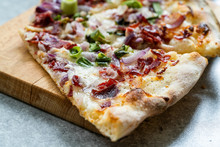 Flammkuchen Pizza Slices / Traditional Tarte Flambee With Creme Fraiche, Cream Cheese, Bacon And Red Onions On Wooden Board.