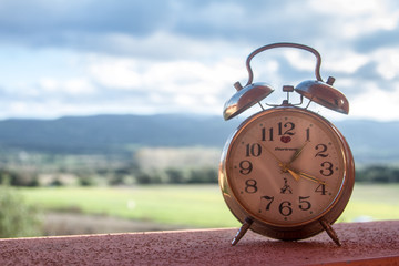 an ancient clock alarm counts time with moving clouds in the background