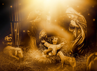 The statue of Mary Joseph and Jesus, Jesus' birthday baby is a statue of Maria and Joseph and Jesus, a newborn baby. There is a beautiful aura light on the hay. Christmas nativity scene