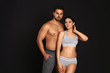 © New Africa - Young couple in grey sportive underwear on black background