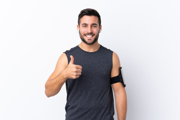 Young sport handsome man with beard over isolated white background with thumbs up because something good has happened