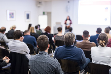 Wall Mural - business and entrepreneurship symposium. female speaker giving a talk at business meeting. audience 