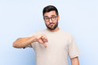 © luismolinero - Young handsome man with beard over isolated blue background showing thumb down sign
