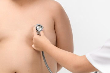 Wall Mural - Little hand doctor check heart by stethoscope to obese boy.