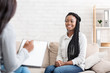 Happy black woman sitting at psychologist office after successful therapy