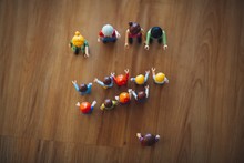 High Shot Of Colorful Plastic Miniature Toys On A Wooden Table Under A White Light