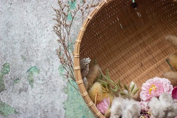 Wall Mural - High angle closeup shot of beautiful flowers in a wooden basket