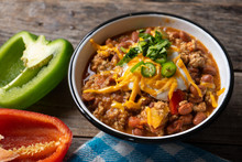 Texmex Dish Called "Chili Con Carne" With Cheese And Sour Cream On Wooden Background