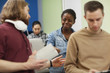 © AnnaStills - African young woman smiling while talking to young man during business seminar at office