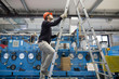 © Westend61 - Young technician climbing up a ladder in an industrial hall