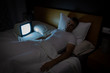 © Cavan Images - A man sleeps with the TV with no signal on in bed at night. Vintage TV