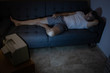 © Cavan Images - A man is watching TV on the couch at night with no lights