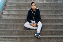 Portrait Of Boy Sitting Outdoors In A Stairs