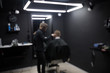 © vfhnb12 - Blurred photo of a barber shop room in black style and lamps.